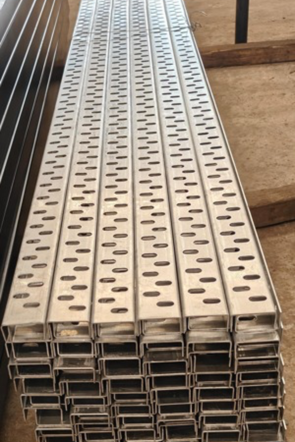 Stacked aluminum perforated cable trays with slotted design for electrical cable management.